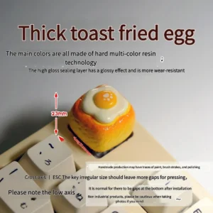 Close-up views of the whimsical handcrafted 3D fried egg toast artisan keycap, showcasing its vibrant yellow and white details from multiple angles.