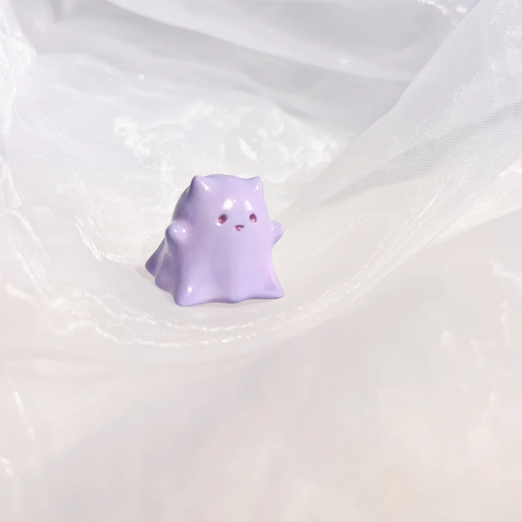 Hand-painted resin Whimsical Ghost Cat Keycap featuring a unique taro-purple head and translucent body, an ethereal piece of art.