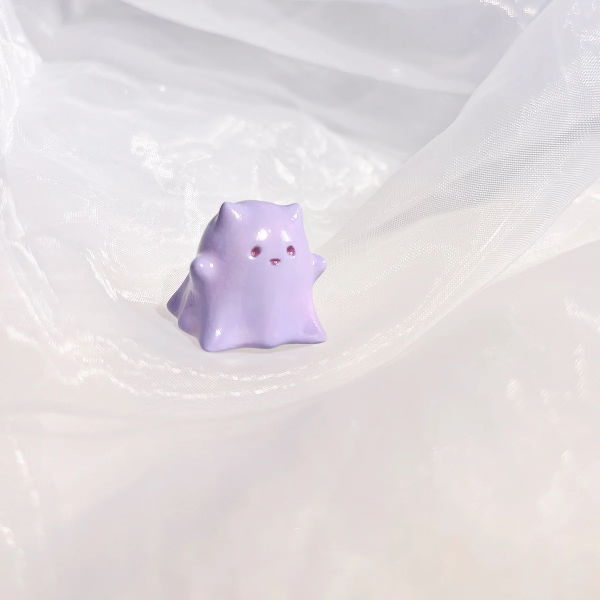 Hand-painted resin Whimsical Ghost Cat Keycap featuring a unique taro-purple head and translucent body, an ethereal piece of art.