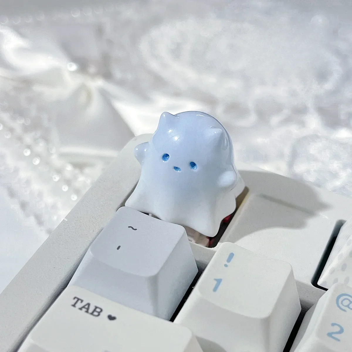 Unique hand-painted resin ghost cat keycap with a whimsical blue-white gradient, embodying a cute and ethereal art style.