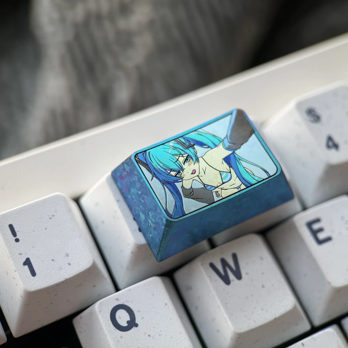 Multiple angles of the exclusive Hatsune Miku Titanium Artisan Keycap (1.5U Tab), showcasing its vibrant anime art and polished titanium craftsmanship.