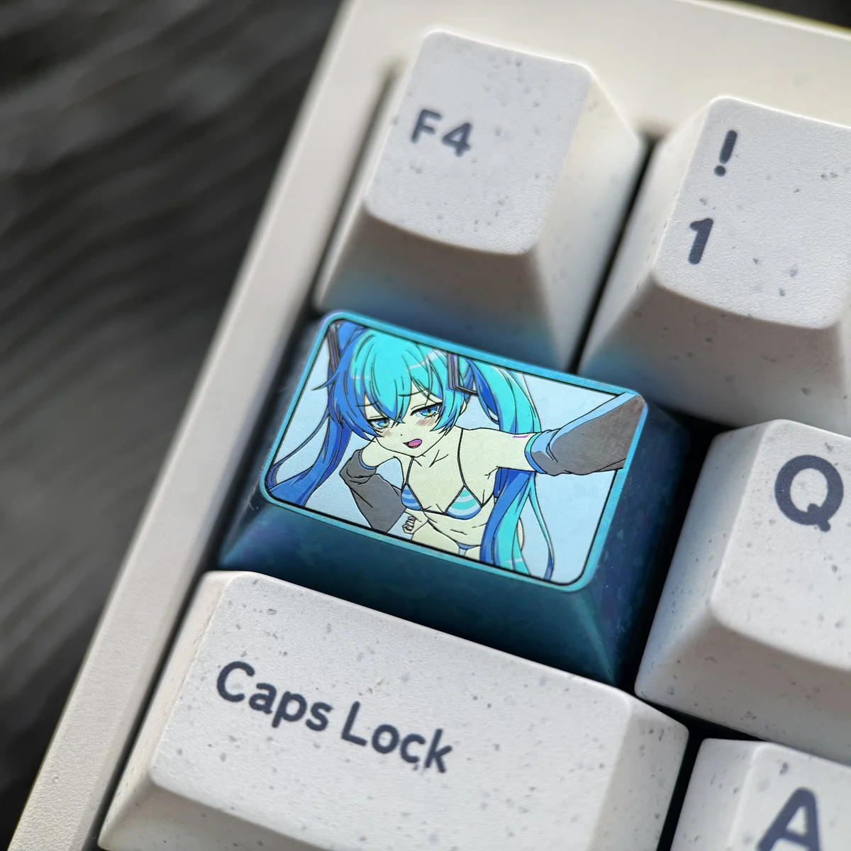 Detailed views of the exclusive Hatsune Miku titanium artisan keycap, showcasing its vibrant anime art and polished finish from various angles.