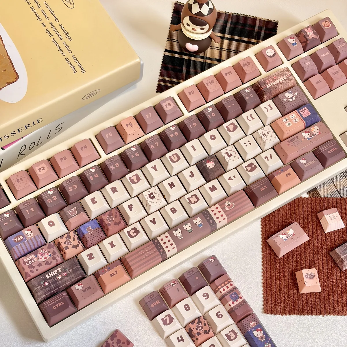 Exclusive Hello Kitty Mont Blanc dessert keycaps set in creamy browns and whites, showcasing various playful angles of this adorable artisan set.