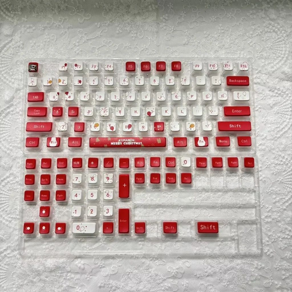 Vibrant Kumamon Christmas keycaps set displayed from various angles, highlighting their festive design and playful four-sided RGB translucent PBT glow.