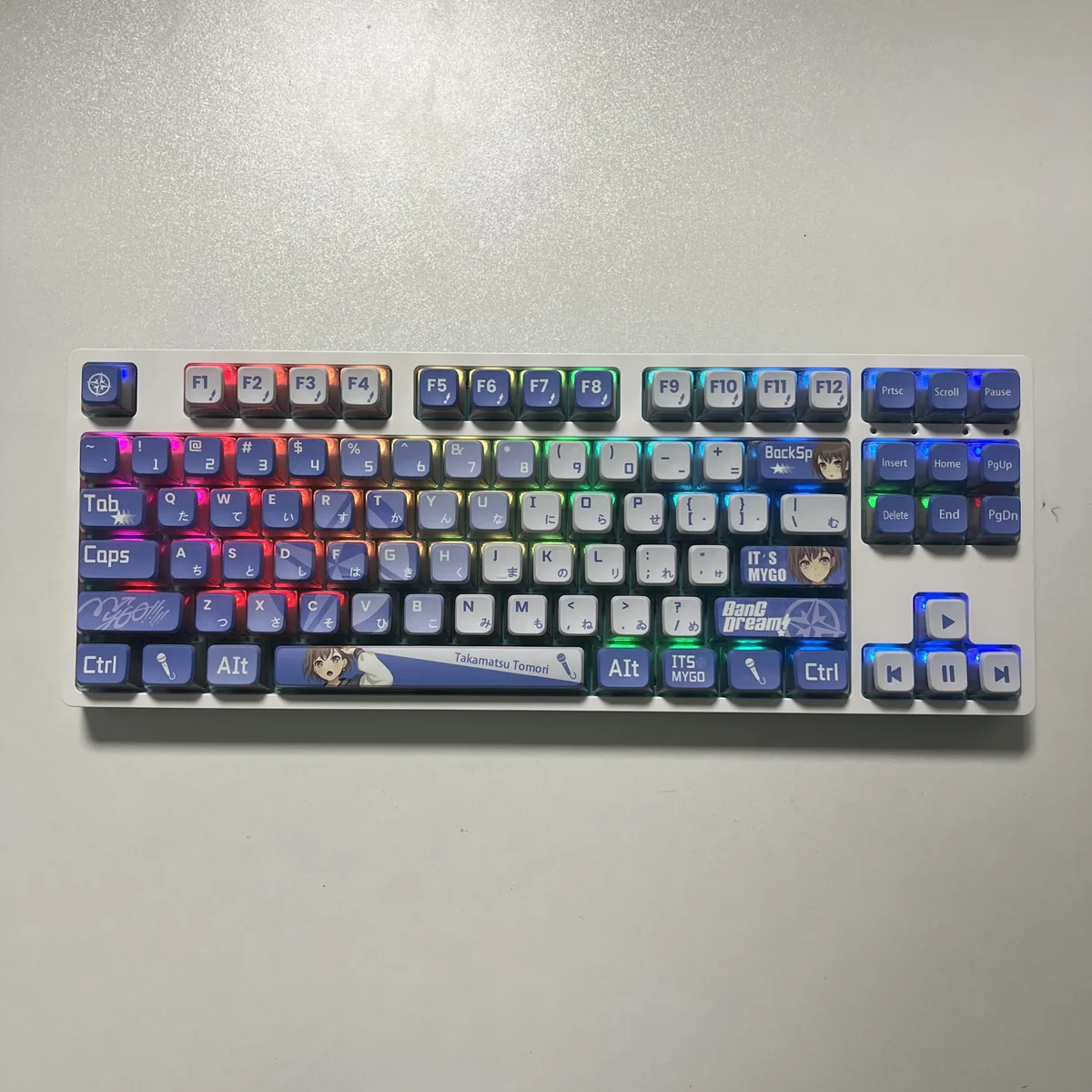 MyGO Tomori translucent PBT keycaps set, shown from an artistic angle, revealing its four-sided glow and vibrant anime design, enhancing an RGB setup.