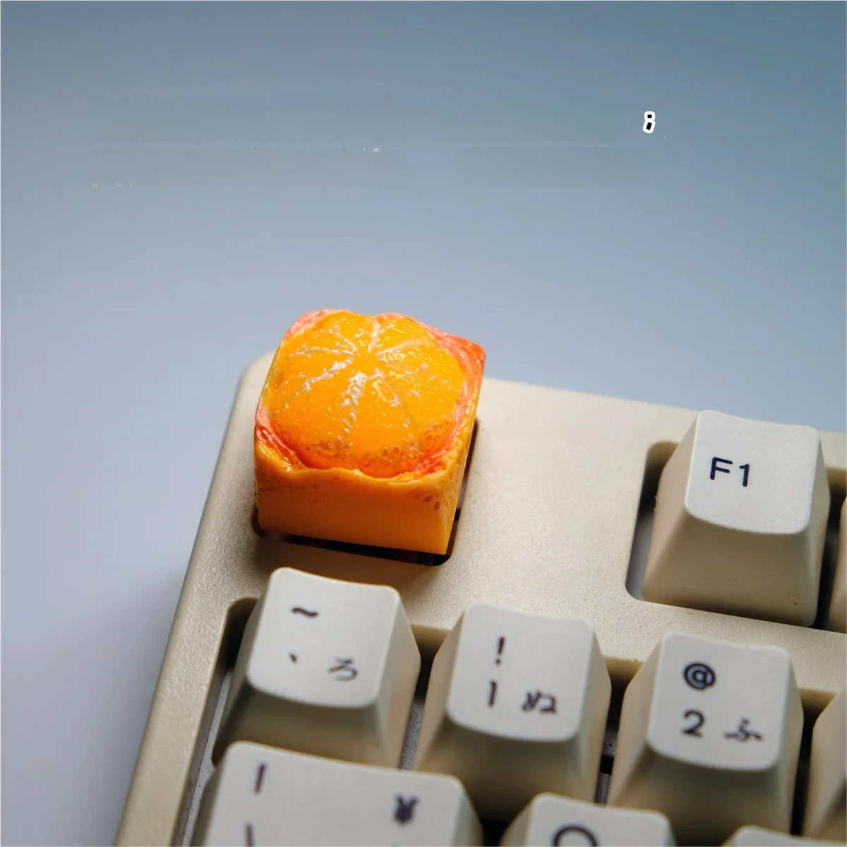 Detailed view of the playful handcrafted orange artisan keycap, revealing its adorable miniature orange fruit sculpture and vibrant whimsical aesthetic.