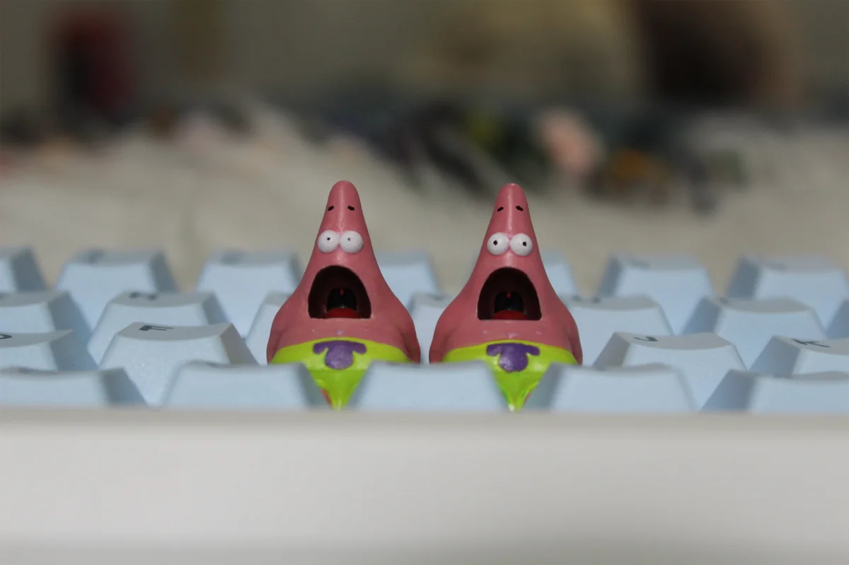 Whimsical handmade Patrick Star keycap crafted from pink resin, shown from various playful angles, highlighting its detailed artisan design.