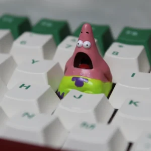 A whimsical handmade Patrick Star keycap, crafted from detailed pink resin, showcasing the beloved cartoon character as a unique artisan accessory.