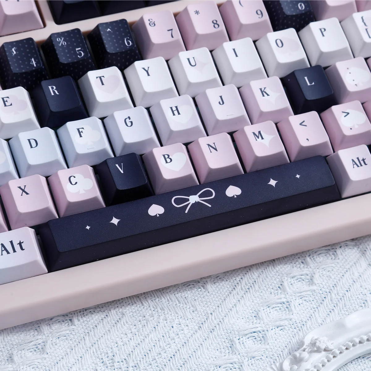 Enigmatic black and vibrant pink artistic PBT dye-sub keycaps set, revealing their unique, subtle legends from diverse angles.