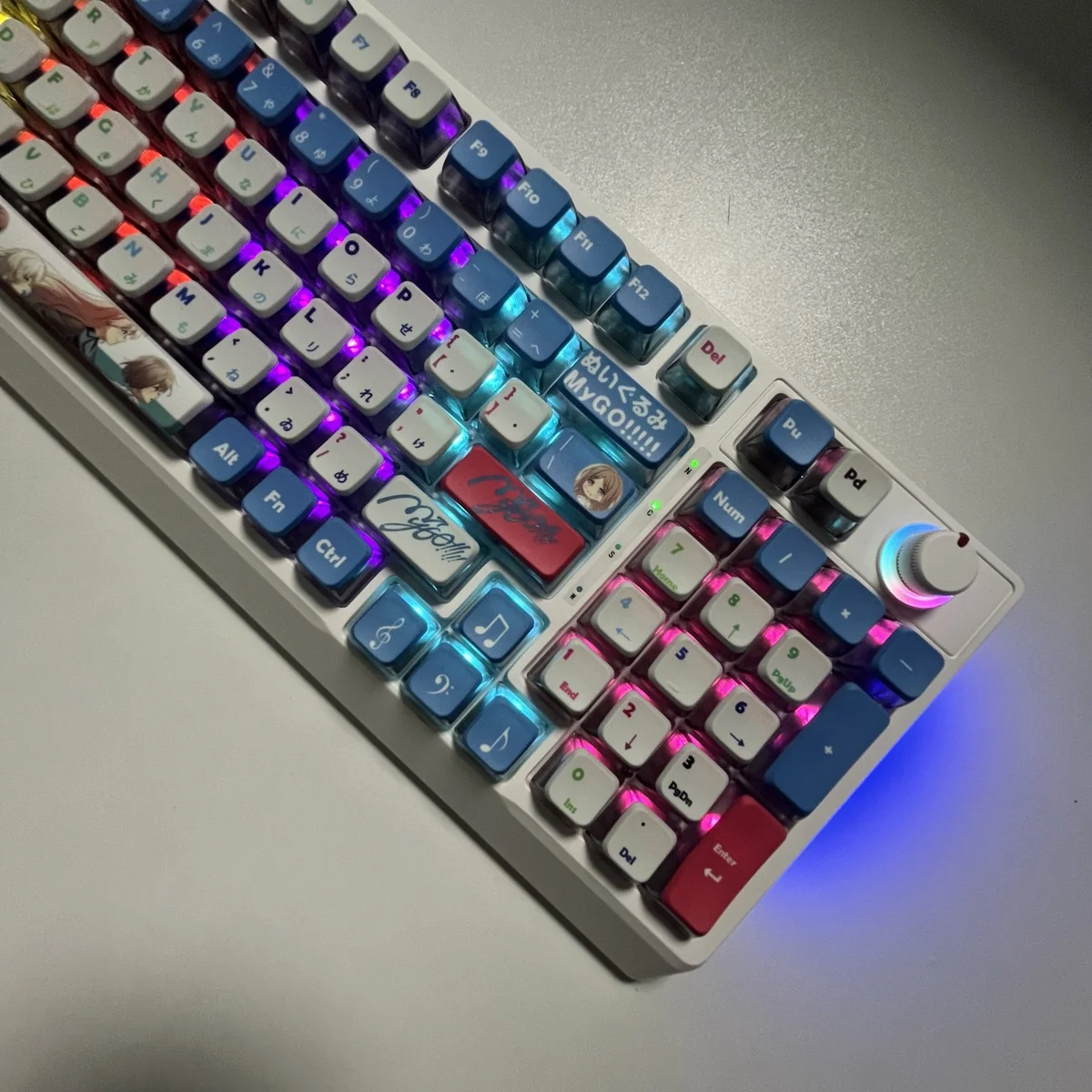 Playful gallery shot of vibrant RGB PBT MyGO Band Theme keycap set featuring a comfortable MDA profile, showcasing their immersive translucent glow from all angles.