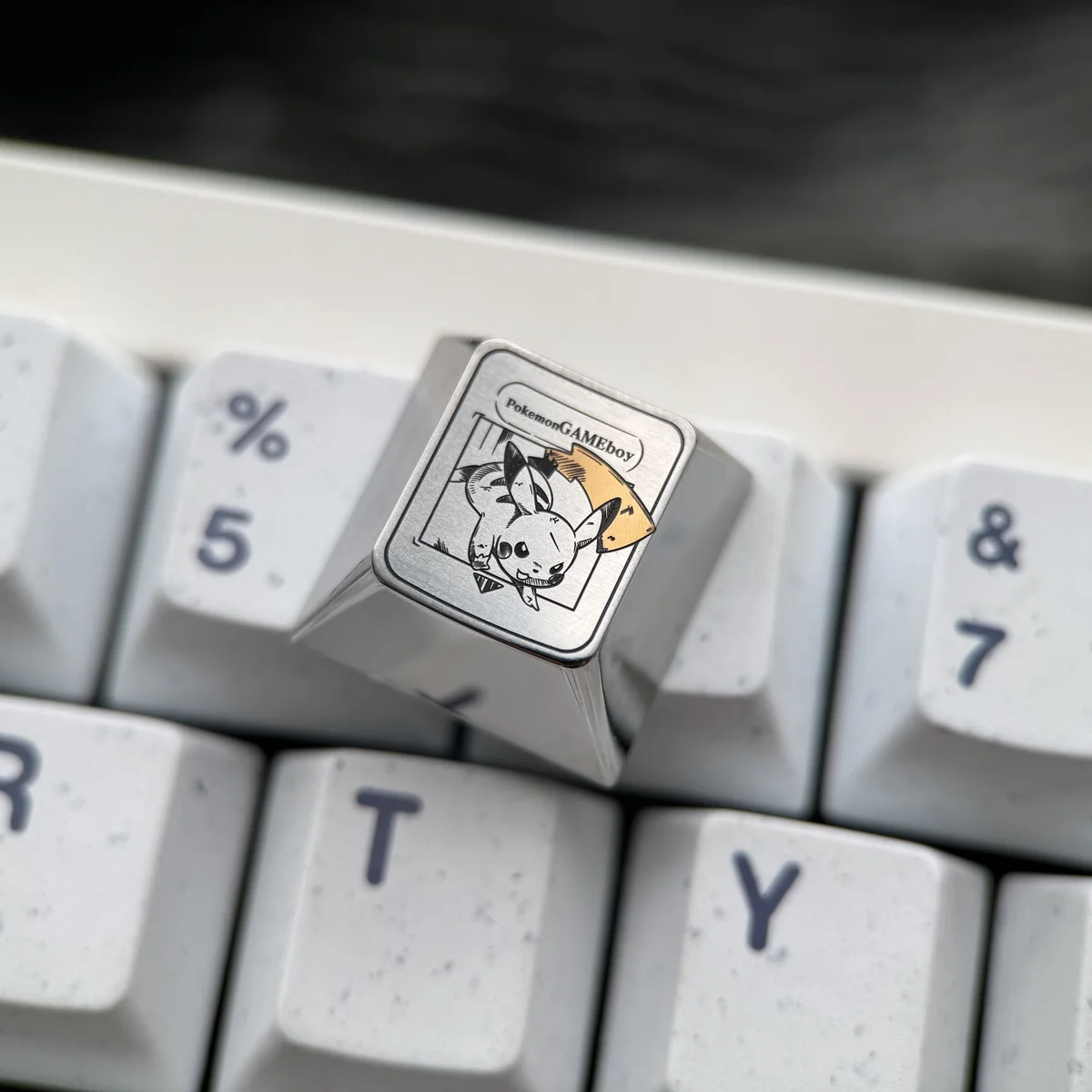 Vibrant Pikachu titanium keycap gallery, highlighting its sleek anodized finish, artisan craftsmanship, and iconic Pokemon design as an ESC key.