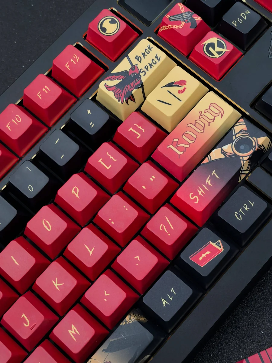 Red Robin Vigilante Keycap Set in striking red and black, featuring iconic DC motifs. This exclusive premium set shown from various angles.