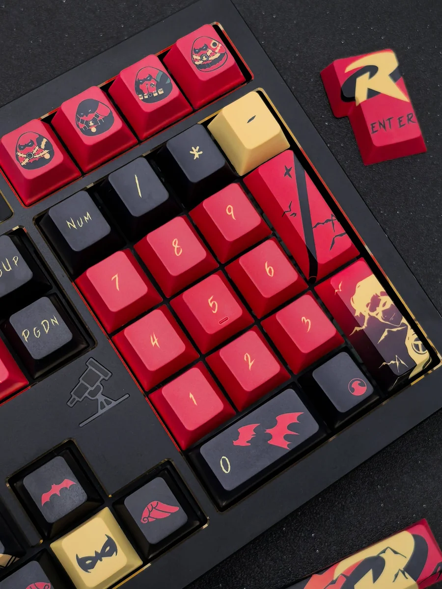 Exclusive Red Robin Vigilante keycap set close-up. Striking red and black DC tribute design, highlighting the premium heroic comic book aesthetic and art.