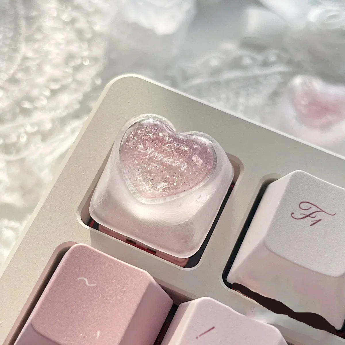 Artistic product gallery of a handcrafted translucent resin heart keycap, revealing its romantic design and angelic motifs from various angles.
