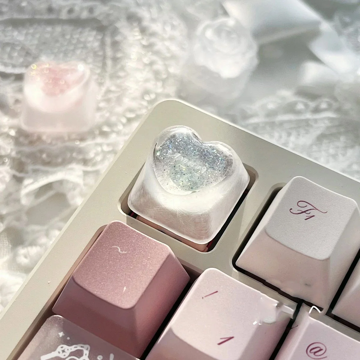 Handcrafted translucent resin heart keycap with delicate angelic motifs, shown from various angles to highlight its romantic charm.