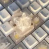 Ethereal handcrafted silk butterfly keycap shown from multiple angles, showcasing its delicate silk bow artisan detail. A whimsical, high-quality accessory.