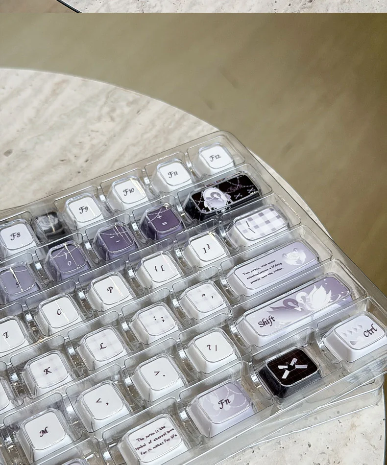 Multiple views of the handcrafted Ethereal Swan Realm Keycap set, showcasing its translucent amber and deep purple double-layer design with an intricate design.