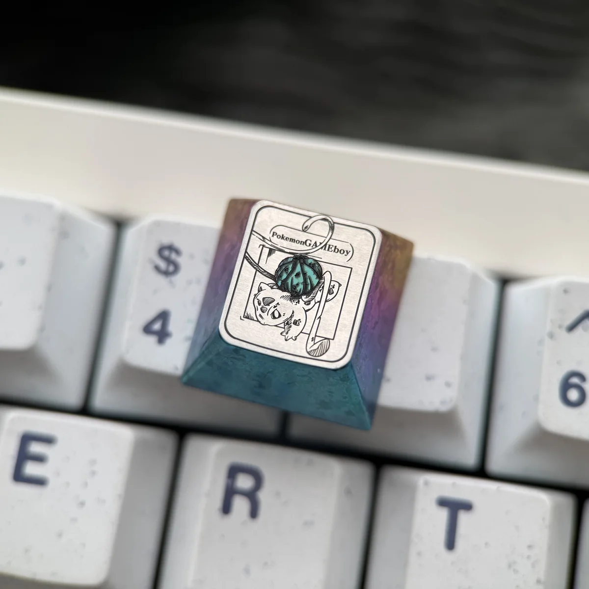 A gallery view of the handcrafted iridescent titanium Bulbasaur Pokemon keycap, revealing its vibrant details from various perspectives.