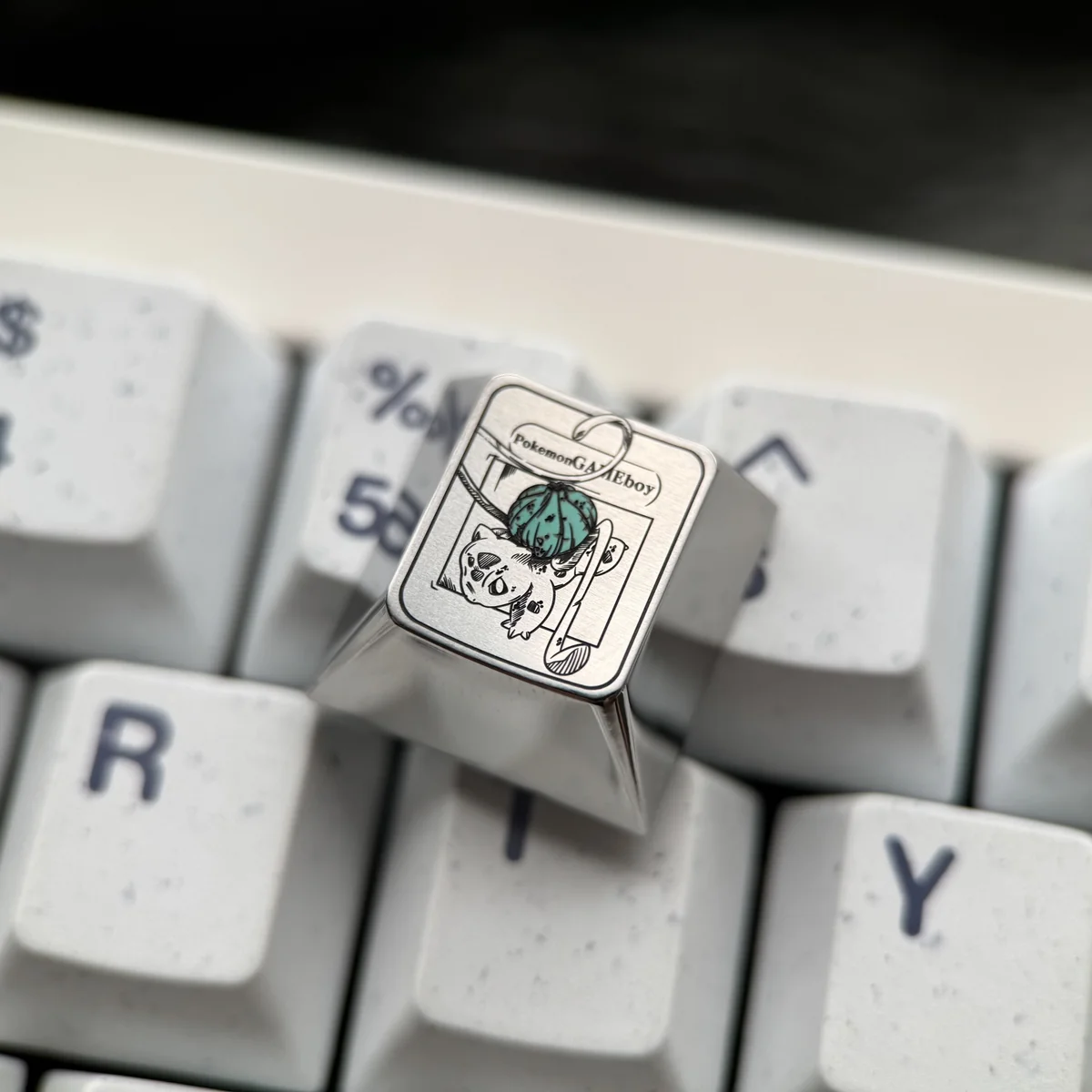 Handcrafted Bulbasaur iridescent titanium Pokemon keycap displayed from various angles, showcasing its vibrant details and premium finish.