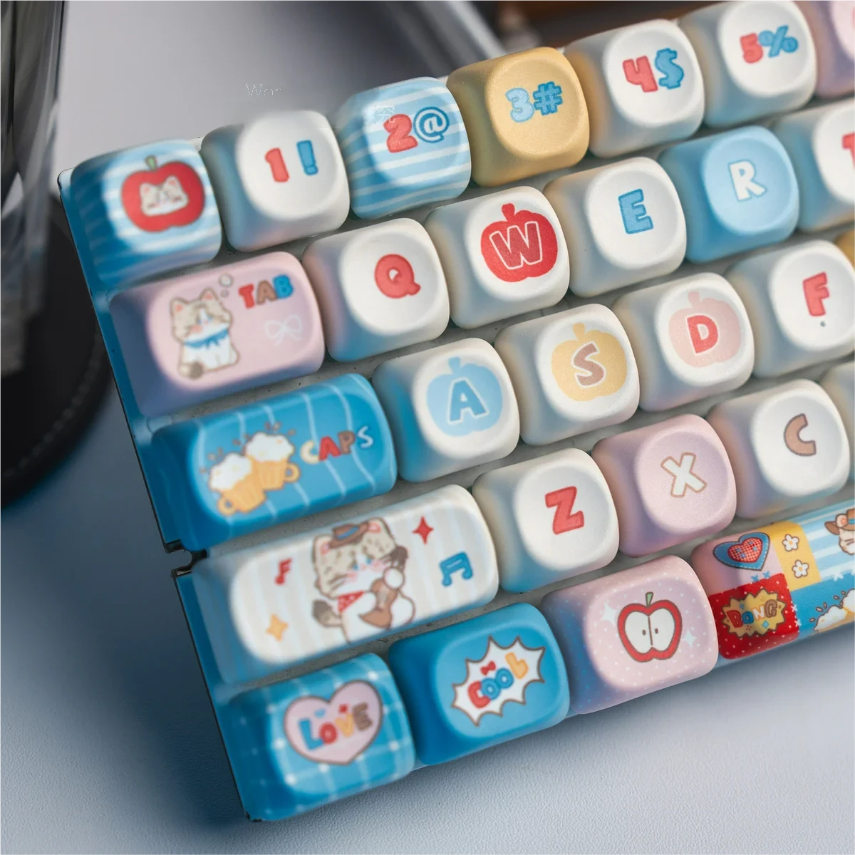 A vibrant close-up of several Western Cat MOA PBT keycaps set, showcasing their unique playful desert theme with adventurous cats in cowboy hats and durable design.