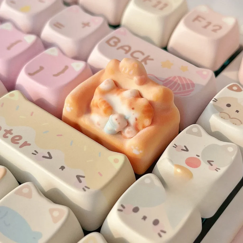 Whimsical hand-sculpted lounging cat keycap in a gallery of views, featuring the charming miniature feline on its cozy, colorful sofa.