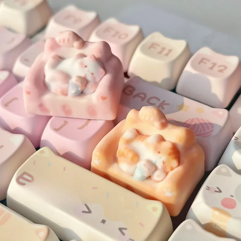 Whimsical hand-sculpted artisan lounging cat keycap from various angles, highlighting the charming miniature feline on its cozy, colorful sofa design.