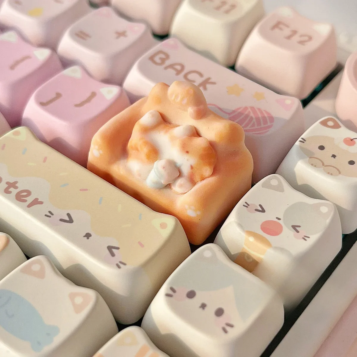 Whimsical hand-sculpted artisan cat keycap featuring a charming miniature lounging feline on a cozy, colorful sofa, viewed from various angles.