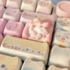 Close-up of a whimsical hand-sculpted artisan cat keycap, showing a charming miniature lounging feline on a cozy colorful sofa from various angles.