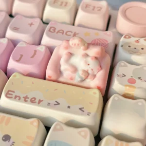 Close-up of a whimsical hand-sculpted artisan cat keycap, showing a charming miniature lounging feline on a cozy colorful sofa from various angles.