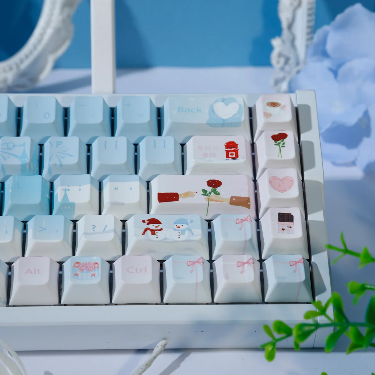 The Winter Romance PBT Dye-Sub keycaps set, presented from various angles, highlight their cozy pastel blue and pink aesthetic and high-quality dye-sublimation.