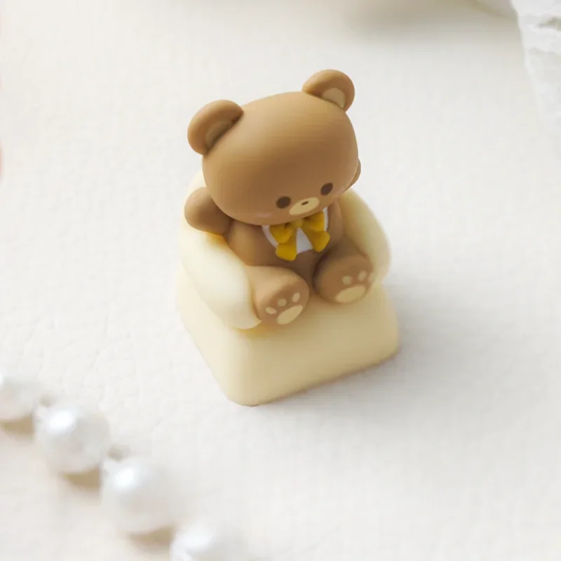 Detailed close-up of the whimsical sofa bear artisan keycap, revealing its intricate layered resin construction and charming miniature bear scene.