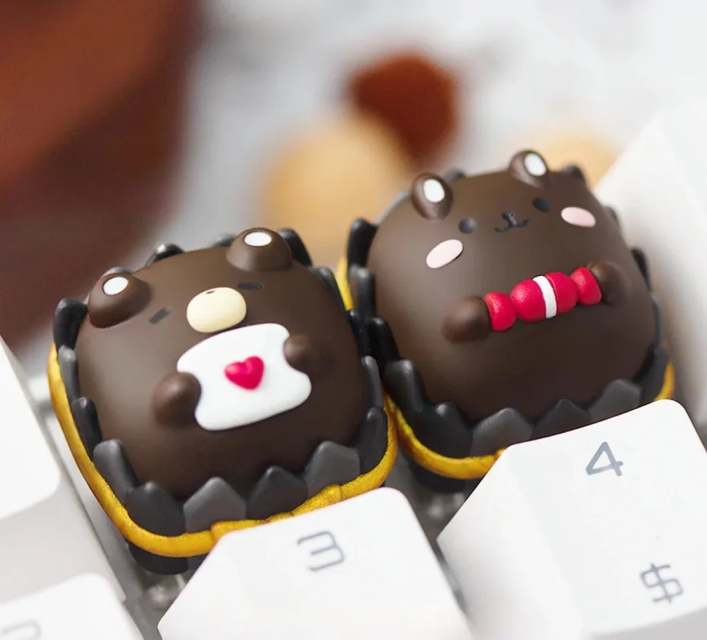 Whimsical chocolate animal artisan keycap, a handcrafted resin keycap with charming miniature chocolate creatures encased in clear resin.