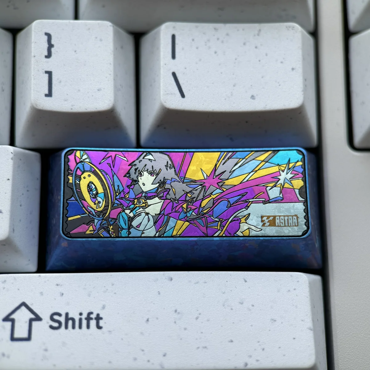 A handcrafted Astra Yao iridescent titanium artisan keycap, featuring shimmering cosmic patterns and celestial artistry for a premium finish.