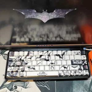 Iconic Batman PBT keycaps set featuring subtle, illuminated side-engraved legends, showcasing their shine-through effect against a dark, mysterious Gotham design.