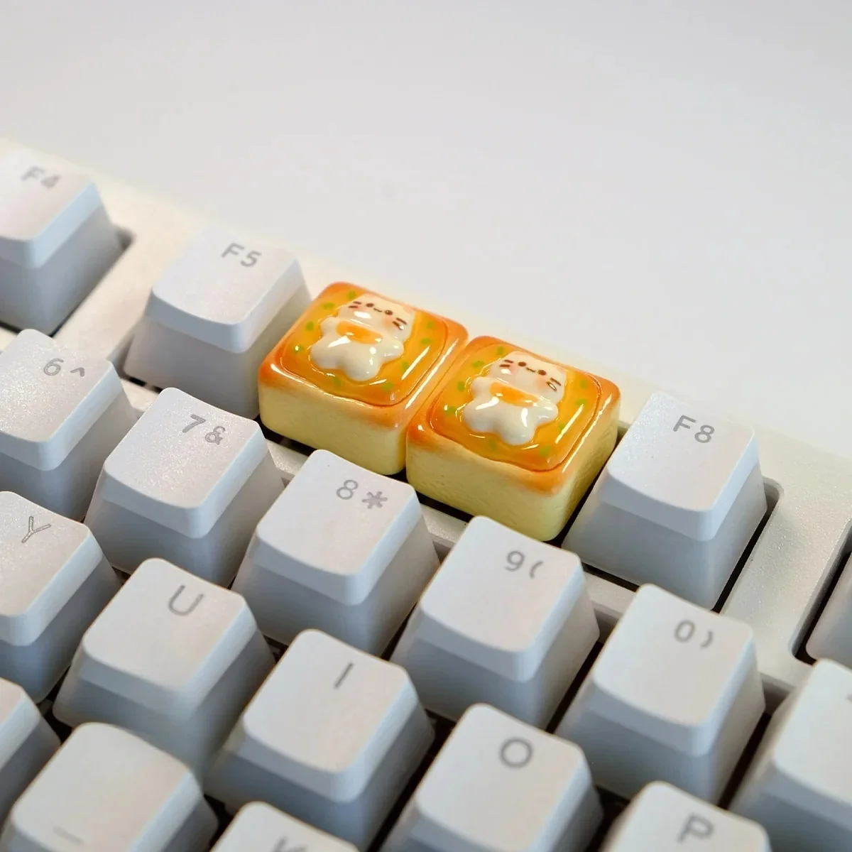 Whimsical handcrafted cat toast keycap from a unique angle, showcasing the adorable sleepy cat on golden toast, a charming keyboard charm.