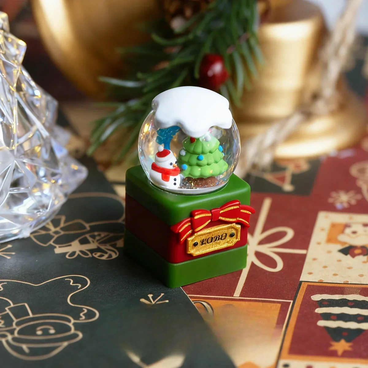 Multiple views of a handcrafted artisan Christmas crystal ball keycap, revealing the intricate miniature wonderland scene encased in clear resin.
