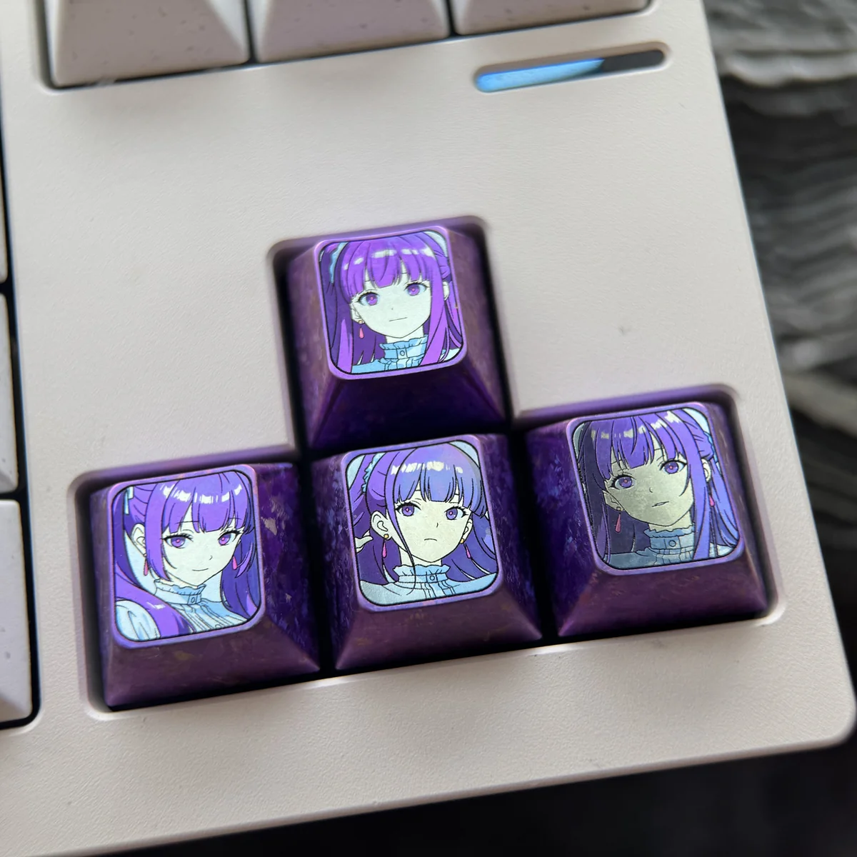 Exquisite Frieren-themed titanium artisan keycap combo for directional keys, showcasing vibrant anodized colors and a luxurious texture.