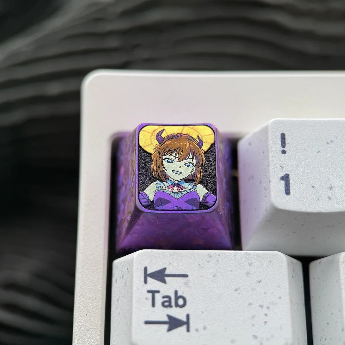 Artistic close-up of the Haibara Ai titanium accent key, emphasizing its unique etched design and premium material for mechanical keyboards.