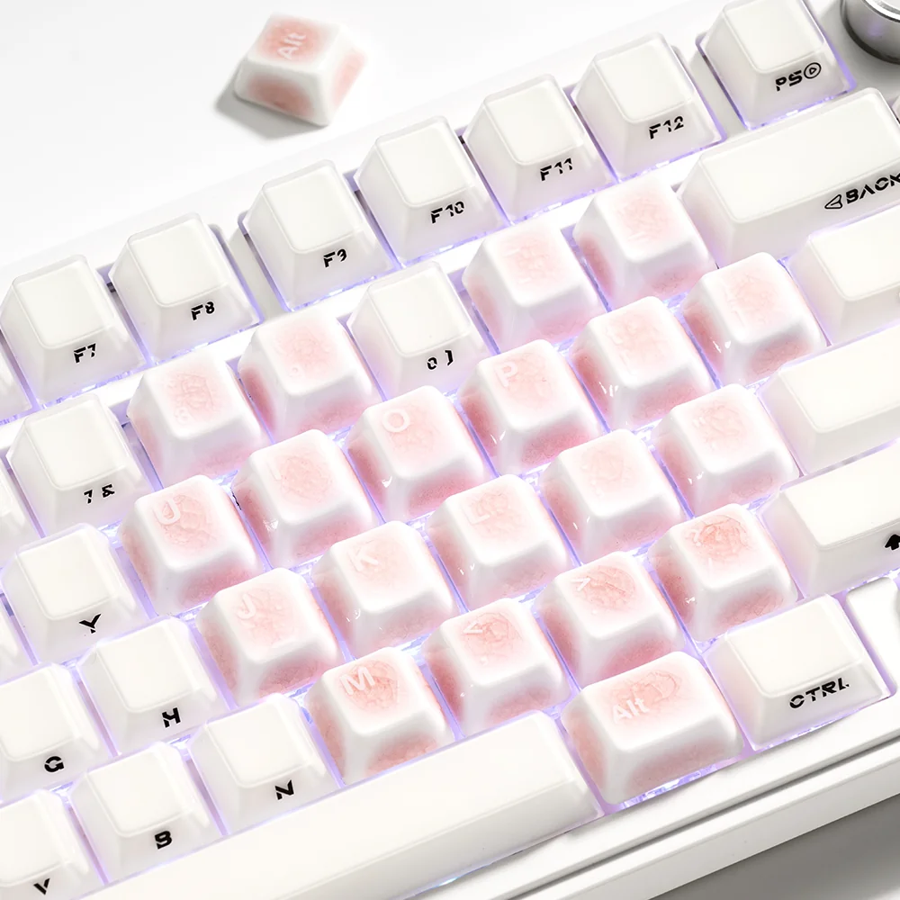 Artistic shot of several handcrafted pink ceramic keycaps, highlighting their heart shape and intricate ice crack patterns from various perspectives.