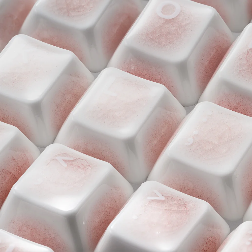 Close-up of a pink ceramic keycap set, revealing the delicate ice crack design and heart motif, emphasizing its premium, handcrafted quality.