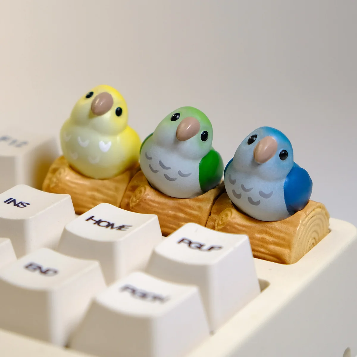 Close-up view of a vibrant, hand-sculpted Monk Parrot artisan keycap, showcasing its intricate details and whimsical charm as unique keyboard art.