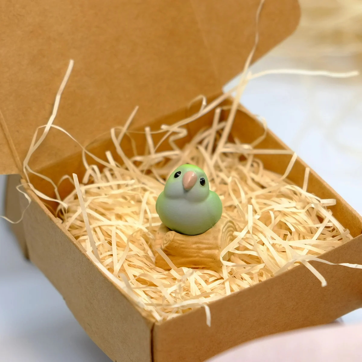 A vivid, hand-sculpted Monk Parrot artisan keycap, captured from a unique angle, revealing its whimsical 3D design and charming, natural artistic appeal.