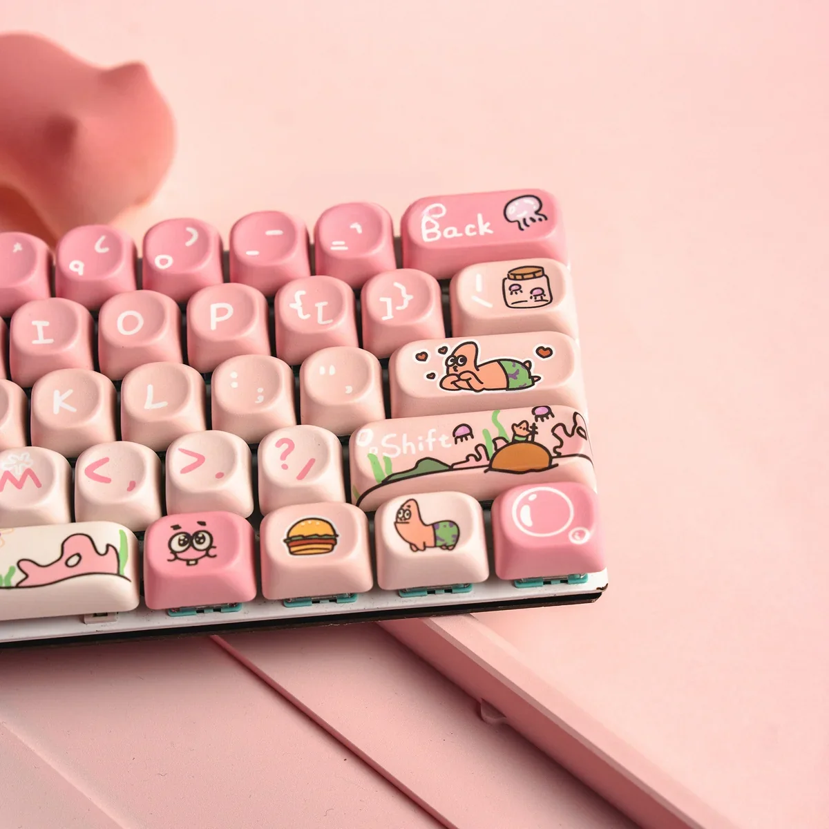 Whimsical Patrick Star PBT MOA keycaps set from different angles, showcasing the cute pink dye-sublimated designs and ergonomic profile for a playful desk.