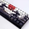 Side view of the durable PBT keycap set, highlighting crisp side-printed 'Sunset War' legends and vibrant, battle-worn sunset graphics.