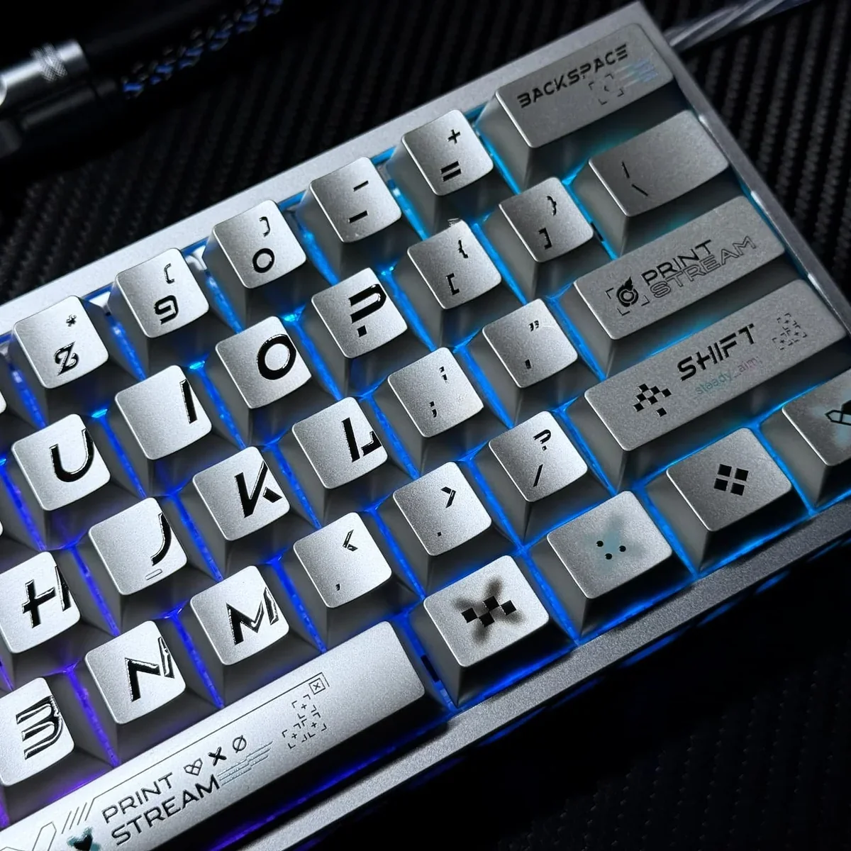 Close-up views of the iconic Printstream keycaps set, showcasing their dynamic graffiti design with a striking contrast of metallic sheen and smooth design.