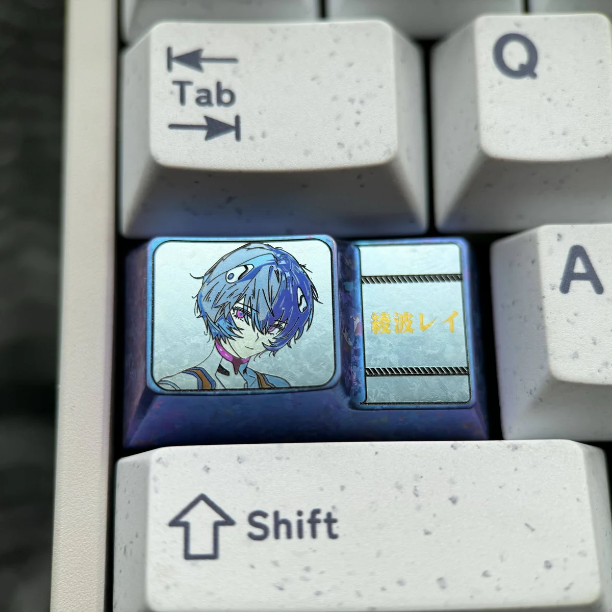 Detailed view of Rei Ayanami titanium alloy keyboard cap, showcasing its unique anodized finish.