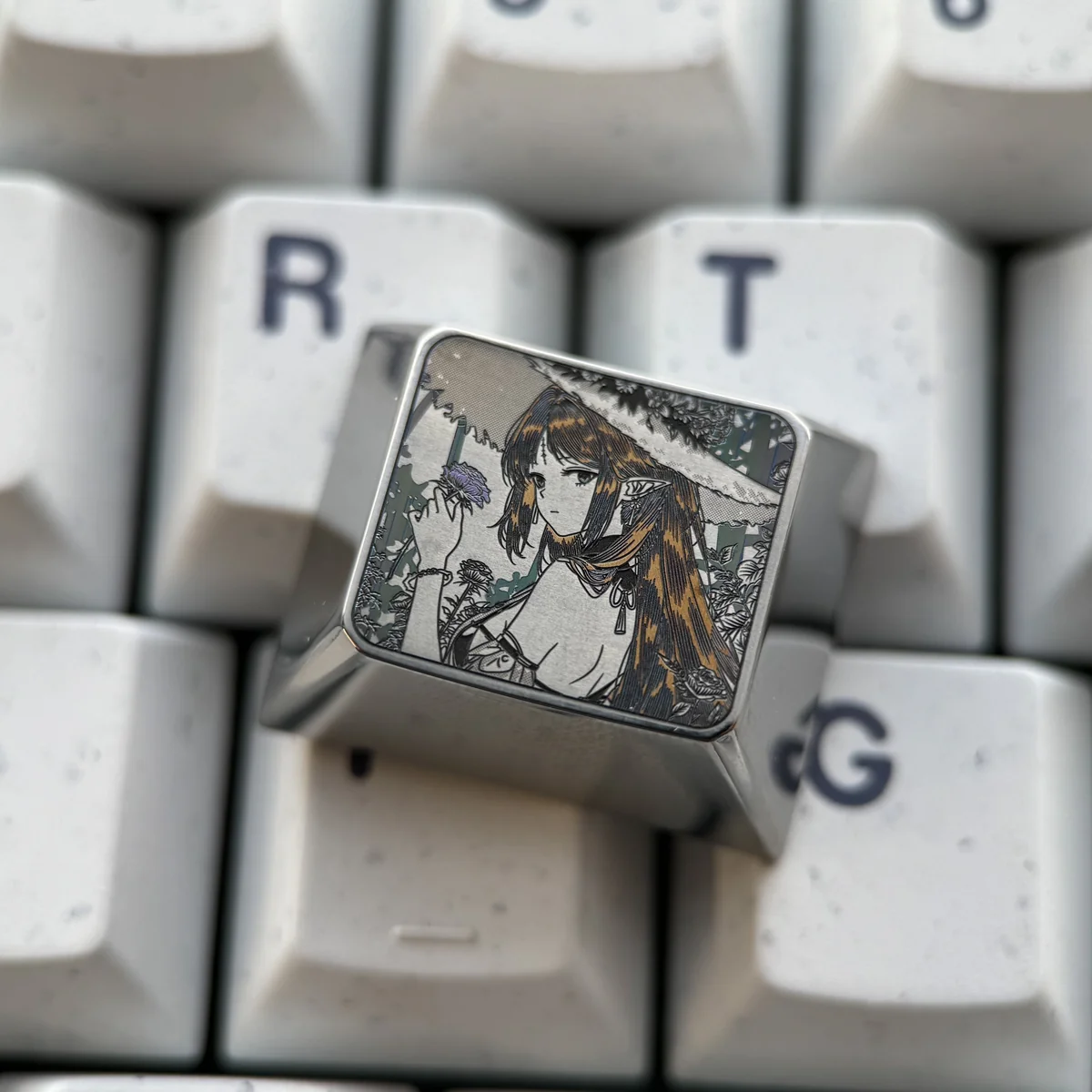 Close-up views of the Cartethyia precision-engraved titanium keycap, showcasing its aerospace-grade material and intricate metallic patterns from various angles.