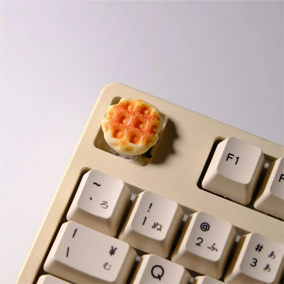 A delightful handcrafted waffle keycap for MX keyboards, showcasing its miniature, realistic design with warm textures from various angles.