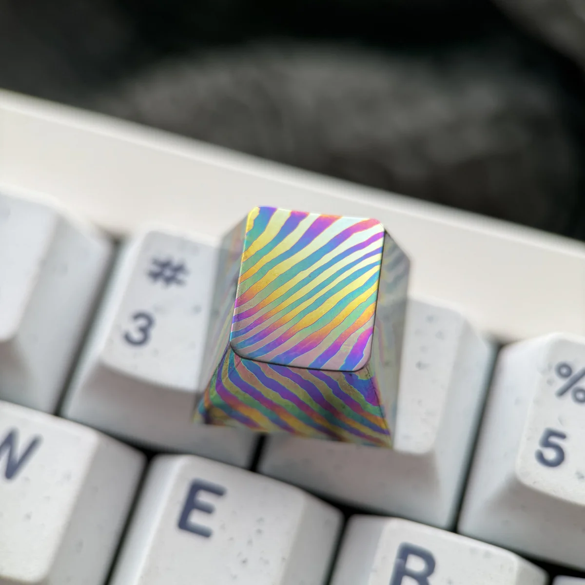 Close-up of unique swirling Damascus pattern on a titanium keycap