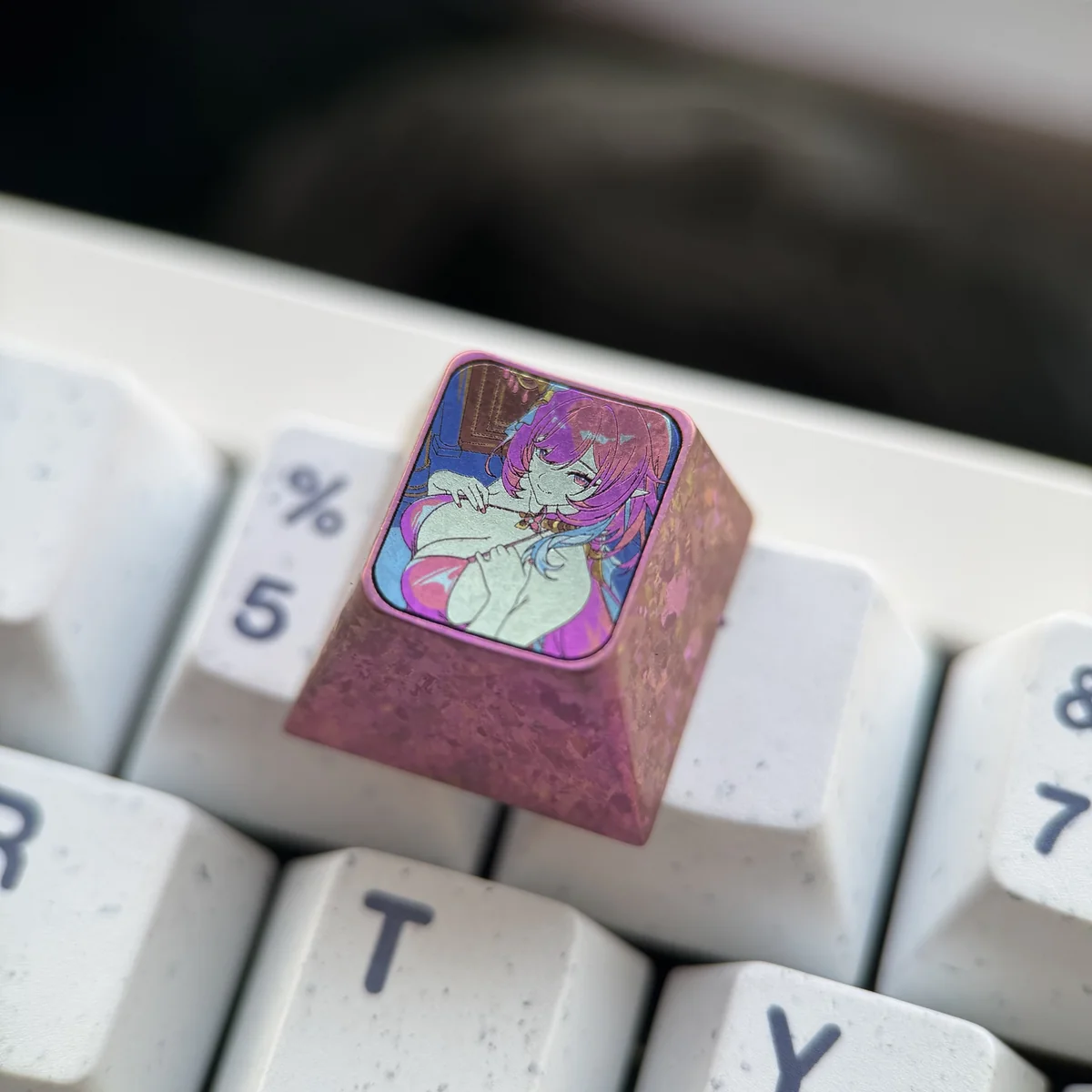 Detailed close-up of the CNC-machined Elysia character art on the polished titanium keycap surface.